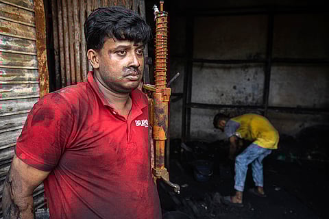 Nizam Uddin stands in front of his burnt shop